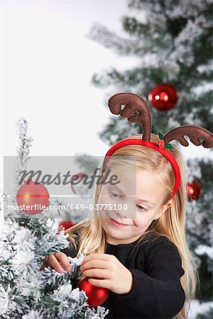 Fille décorer un arbre de Noël