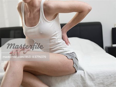 Young woman sitting on bed