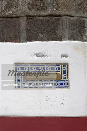 Madeira. Detail of letterbox with blue and white tiled surround set into brick wall