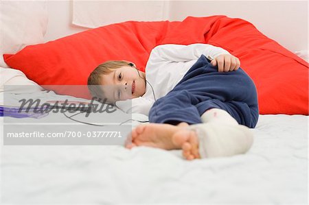 Garçon avec Cast sur jambe portant des écouteurs