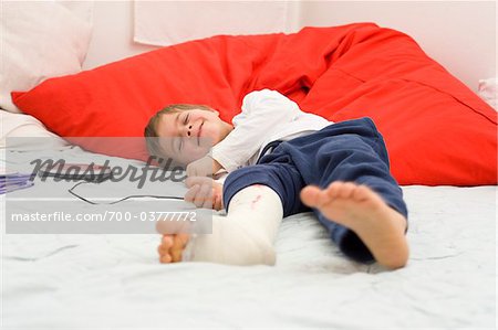 Boy with Cast on Leg Listening to CD Player