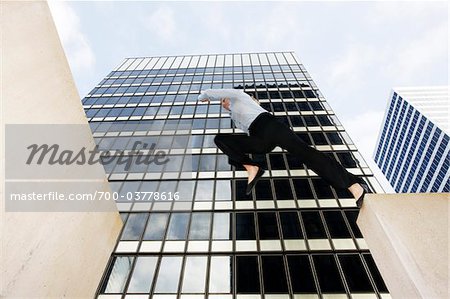 Businesswoman Jumping Gap in front of Office Building