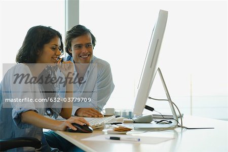 Couple regarder ensemble, ordinateur de bureau les deux souriant