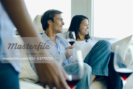 Couple bénéficiant d'un vin rouge sur canapé