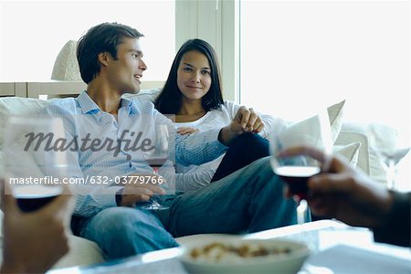 Couple enjoying red wine with friends