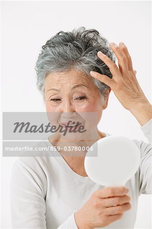 Senior Adult Woman Looking Herself In Hand Mirror