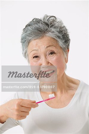 Senior Adult Woman Looking Holding Zahnbürste
