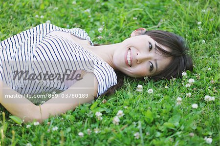 Young Woman Lying On A Grassy Field