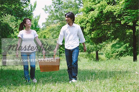 Couple Walking in Park Holding Basket