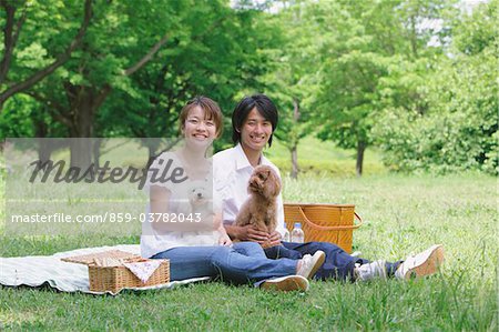 Young  Couple Playing with Toy Poodle Dogs