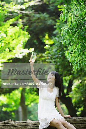 Junge Frau im Park Holding Glas Wasser