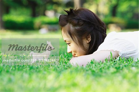 Jeune femme couchée sur l'herbe et jouer avec des jouets