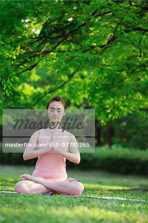 Junge Frau beten in Padmasana Position sitzen