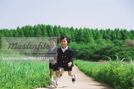 Twins Wearing Uniform are Running in Park