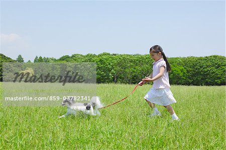 Fille en cours d'exécution dans le parc avec son chien Pet