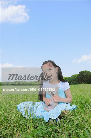 Girl Sitting in Park Holding Puppy