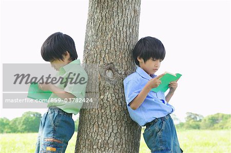 Twins Reading Books in Park