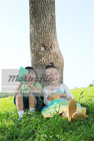 Girl and Boy Sitting in Park