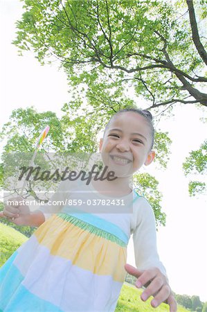 Girl Standing in Park Holding Lollipop