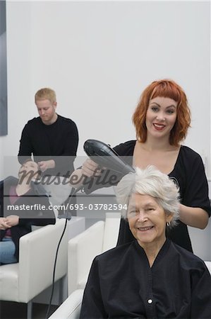Cheveux de styliste blow-drys femme âgée