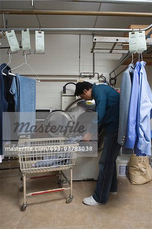 Mann, die Kleidung in die Waschmaschine zu laden