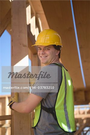 Labourer positioning plank of wood