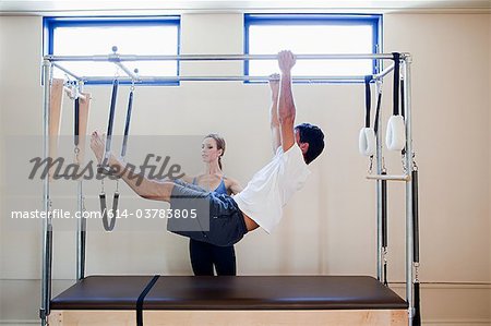 Man doing pilates with instructor