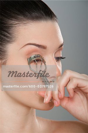 Woman Curling Eyelashes