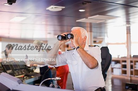 Captain on ship looking through a telescope