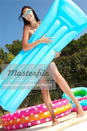 Woman behind air bed by the pool