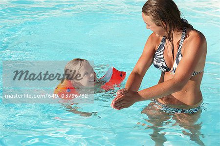 Mother and son playing in swimming pool