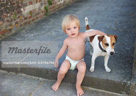 Baby boy playing with a dog