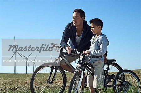 Father and son with bikes by a windfarm