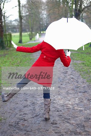 Fille en veste rouge avec brolley dans le parc