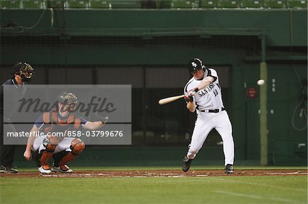 Batter hitting ball while playing baseball