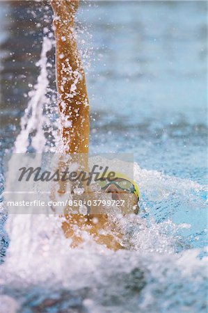 Mid adult man swimming backstroke