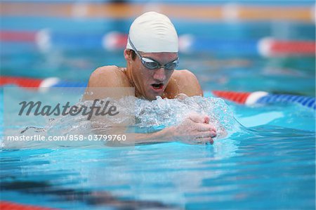 Jeune homme nager dans la piscine