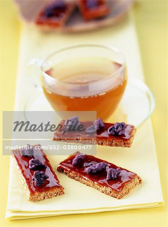 Croquants aux amandes et aux noisettes, au caramel et violettes et une tasse de thé Croquants aux amandes et aux noisettes, au caramel et violettes et une tasse de thé