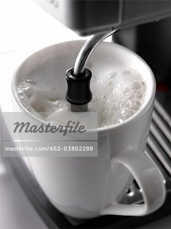 Une tasse de lait avec un percolateur de chauffage