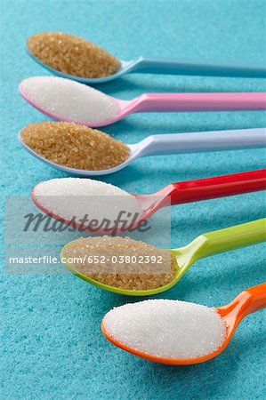 Plastic spoons with white and brown sugar