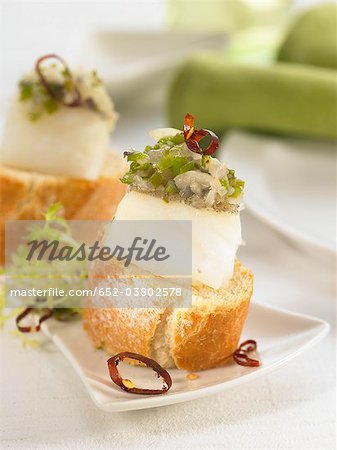 Morue et poivrons verts sur une tranche de bouchées de pain Morue et poivrons verts sur une tranche de bouchées de pain