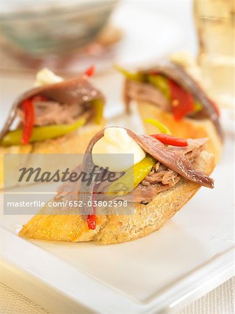 Tuna,anchovies,Guindilla pepper and red pepper on a bite-size slice of bread Tuna,anchovies,Guindilla pepper and red pepper on a bite-size slice of bread