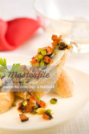 Anchois et poivrons au vinaigre, coupées en dés sur une tranche de bouchées de pain Anchois et poivrons au vinaigre, coupées en dés sur une tranche de bouchées de pain