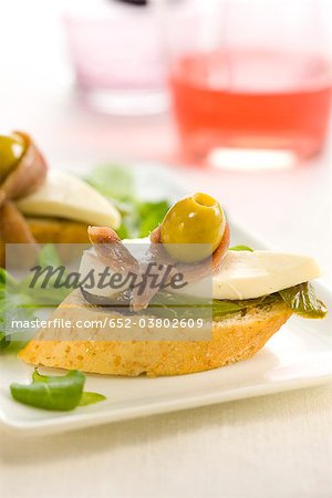 Anchovy,cheese,green pepper and olive on a bite-size slice of bread