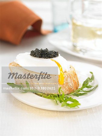 Poached egg and caviar on a bite-size slice of bread