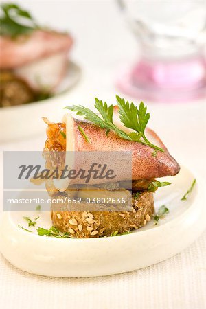 Tintenfisch, Zwiebeln und Auberginen auf einer Scheibe Brot mundgerechte