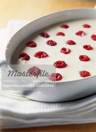 Filling the mould with the mixture and adding the raspberries