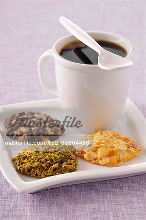 Cup of coffee and three different flavored crunchy cookies