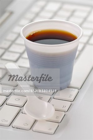 Plastic cup of coffee on a computer keyboard