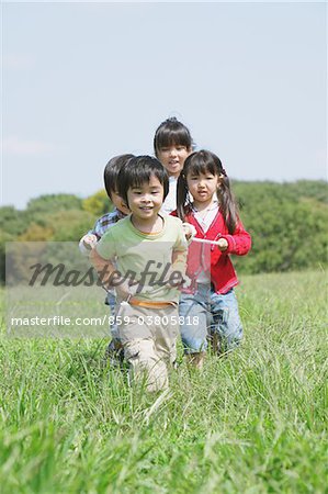 Children Playing In Grassy Field